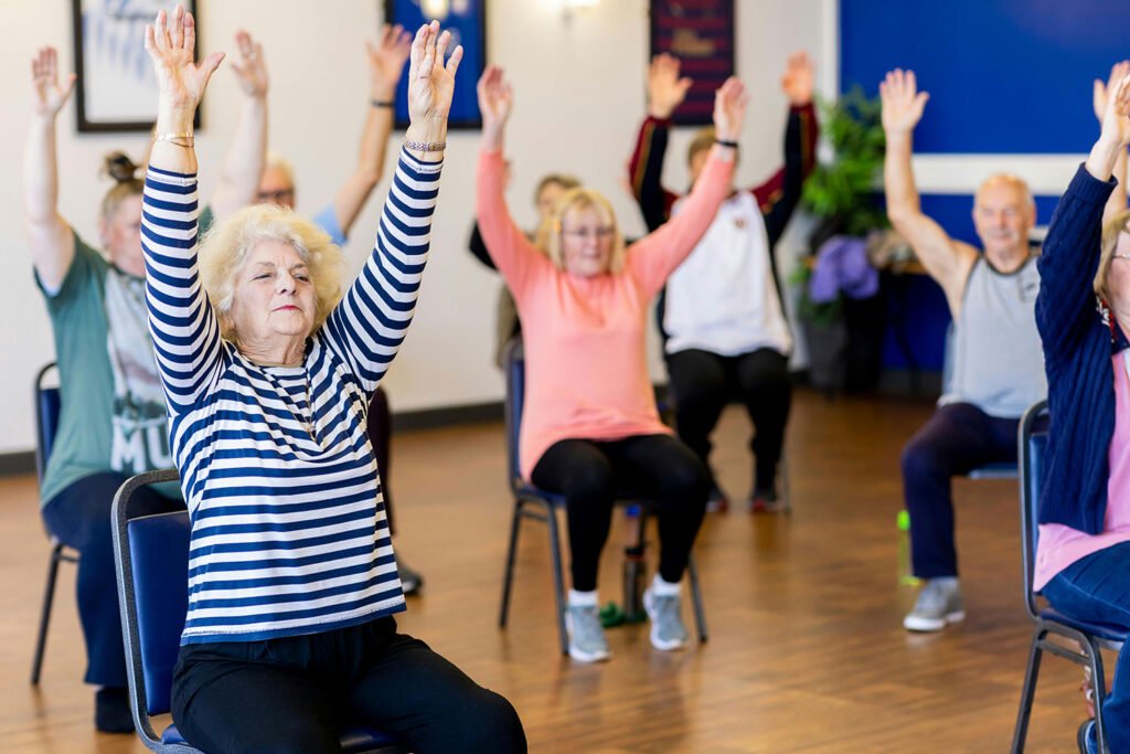 Group of seniors doing chair exercise and yoga