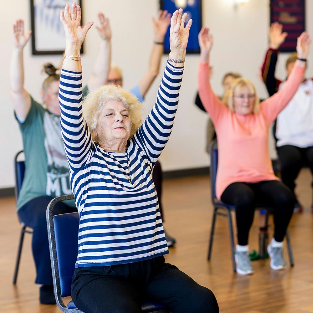 Group of seniors doing chair exercise and yoga