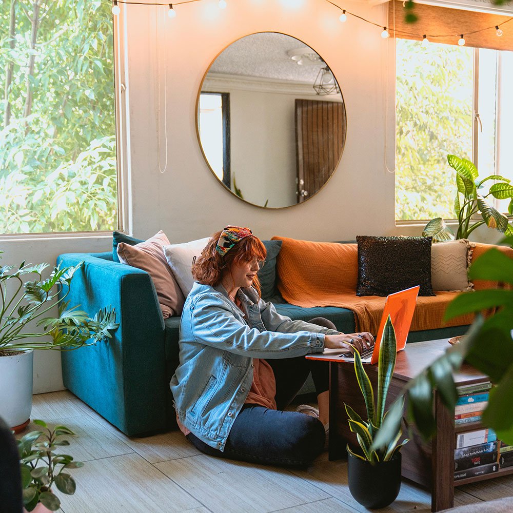 Woman sitting on the floor working with a laptop on a coffee table